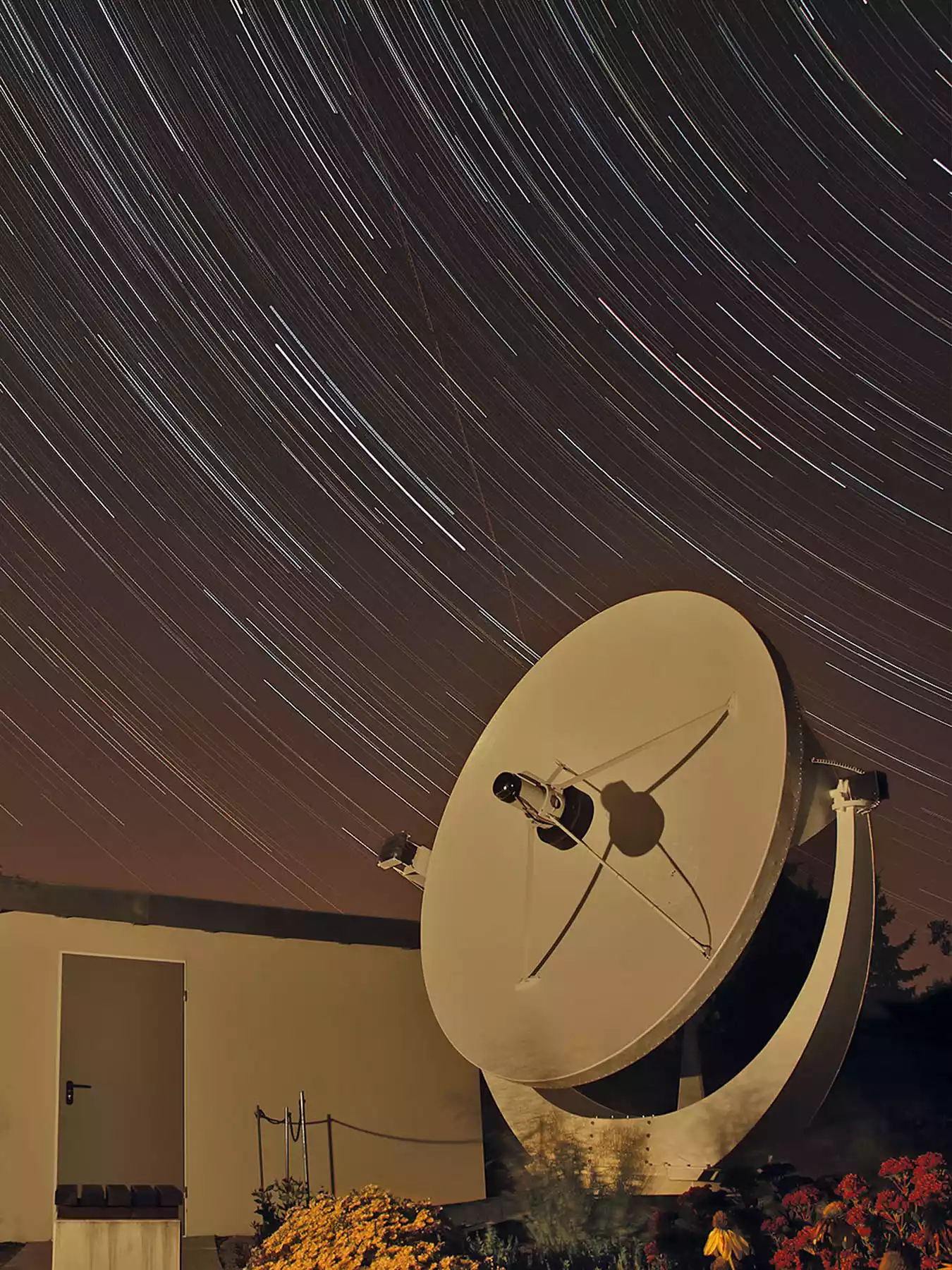 Radioteleskop der Sternwarte Radebeul bei Nacht mit Sternspuren am Himmel durch Langzeitbelichtung